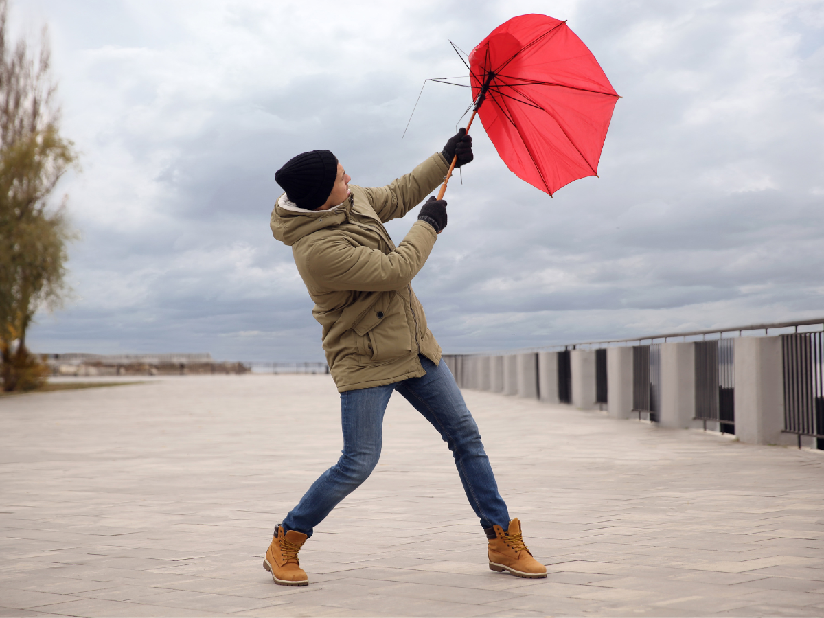 Man holding umbrella broken by the wind. 