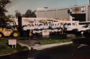 Team posing outside industrial building